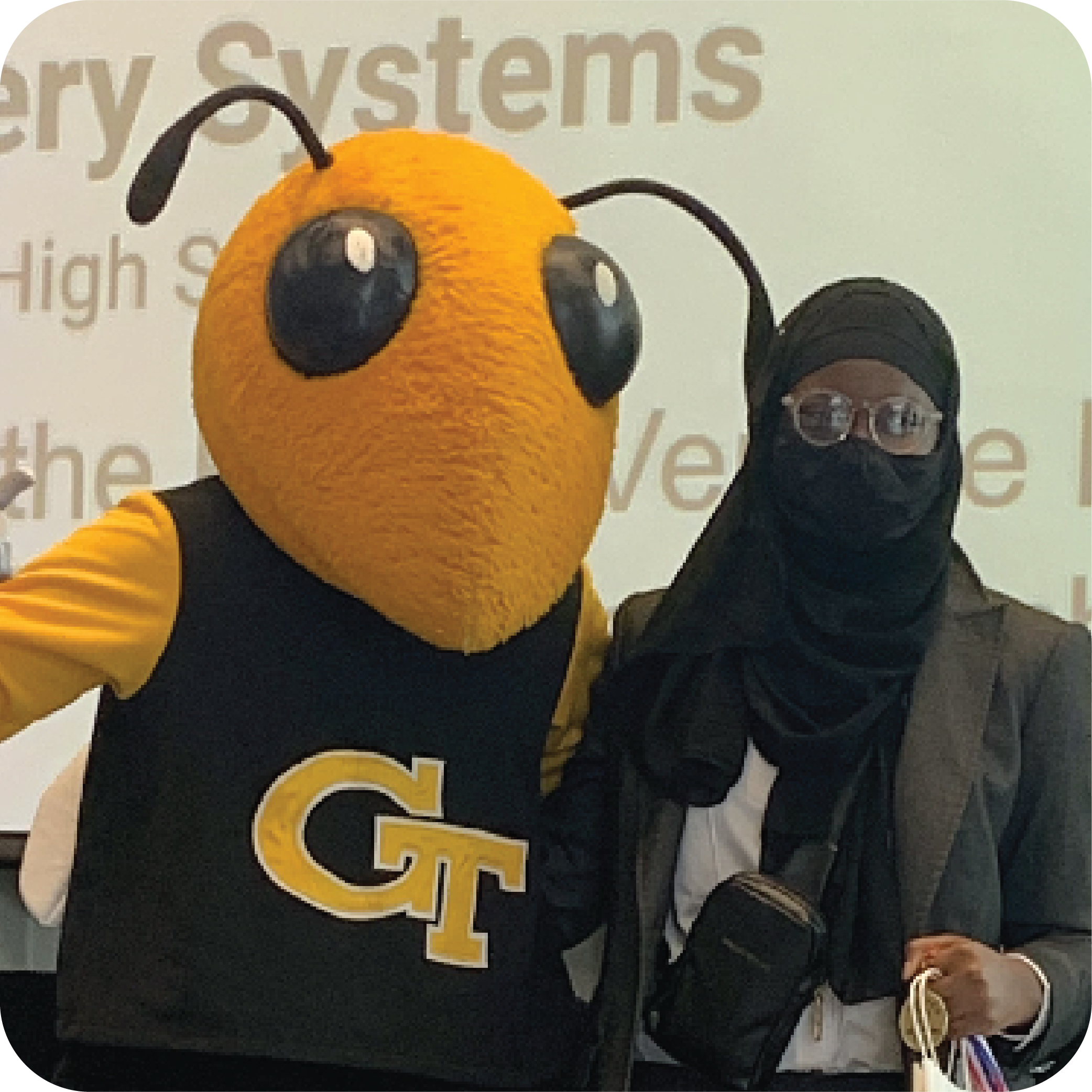 A student standing next to Buzz (Georgia Tech's yellowjacket mascot).